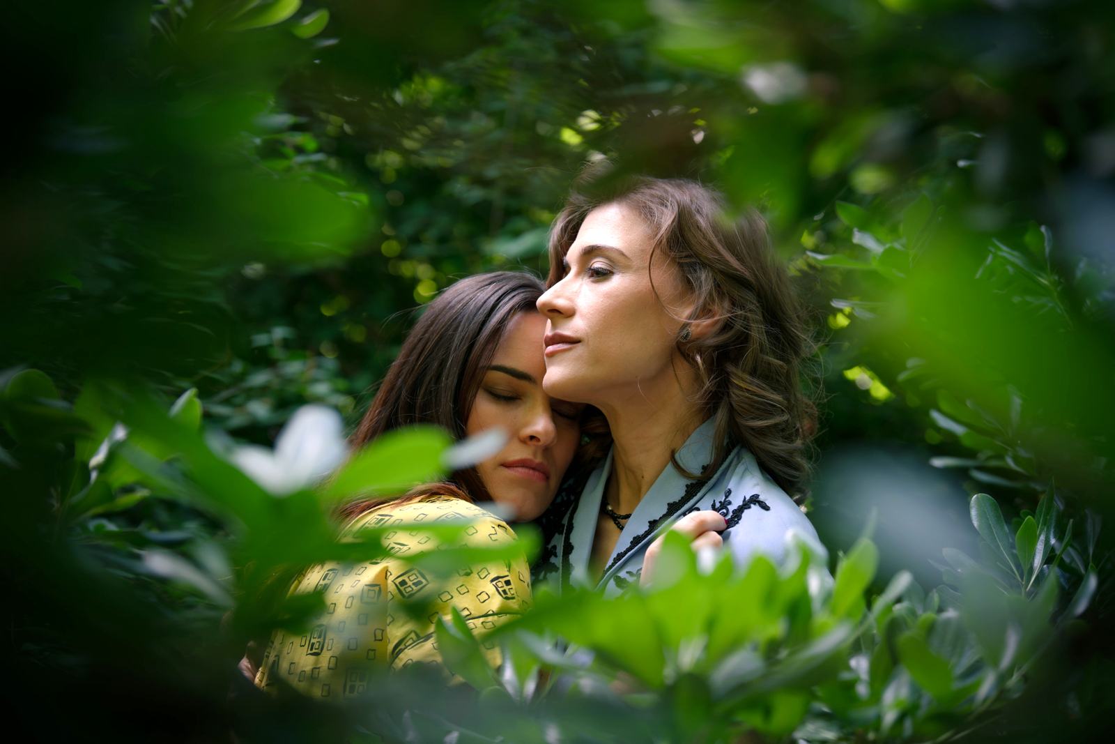 Fina y Marta, entre la arboleda, ignoran que un detective les toma fotos en el capítulo 131 de Sueños de libertad